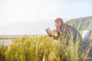 ベンチで読書する男性